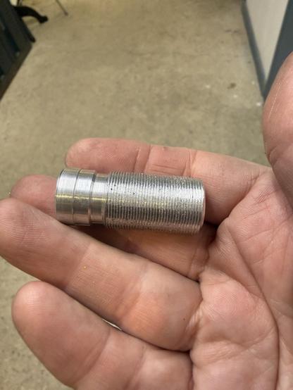 A small round piece of aluminum on Sen’s hand, with 3/4 of it threaded, then a couple different diameter smooth sections with chamfers between them