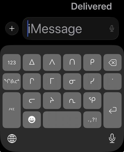 The current iOS syllabics keyboard, which is a 6-wide by 4-tall button grid of characters with a double-wide space bar in the bottom middle, enter/return double tall in the bottom right, and a double tall “shift” type button to access naniit/finals in the lower left.